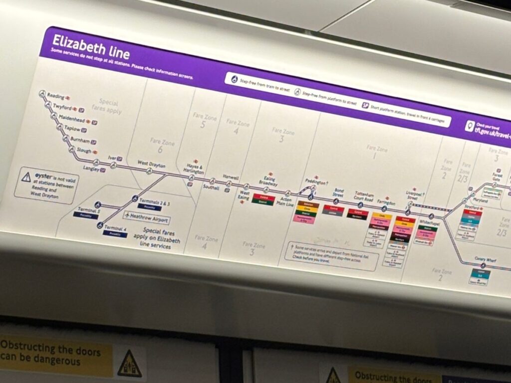 Station map for the Elizabeth Line tube in London as seen from the interior of a tube train with purple and white color scheme.