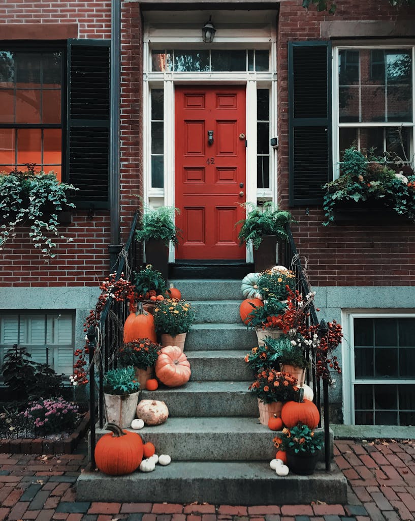 Festive autumn decorations with pumpkins and greenery on a Boston doorstep.