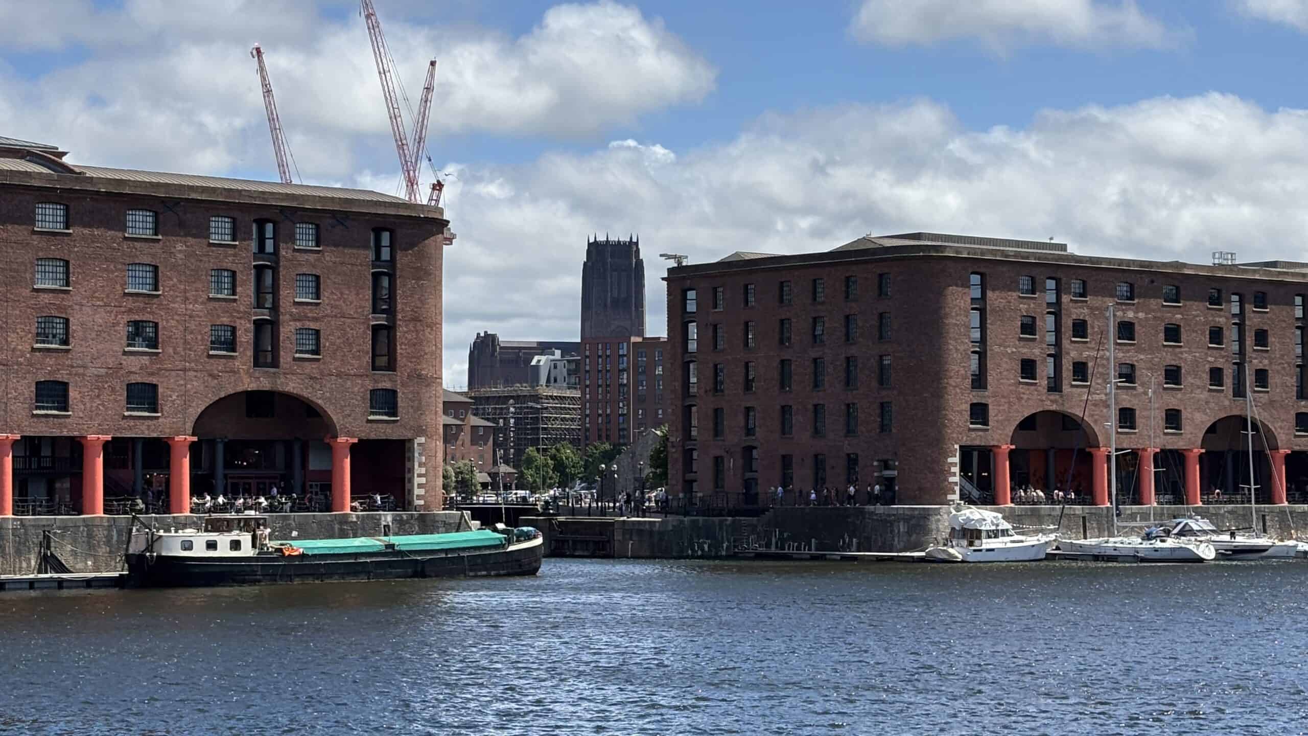 View of Liverpool’s red-brick Albert Dock with the city’s Anglican Cathedral visible in the background.