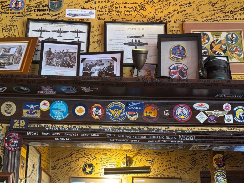Interior of the RAF Bar at The Eagle Pub in Cambridge, England, featuring World War II veteran graffiti on the ceiling and walls.