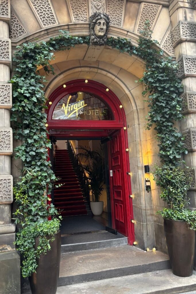 Front of Virgin Hotel in Old Town Edinburgh with distinctive red door and historic building facade.