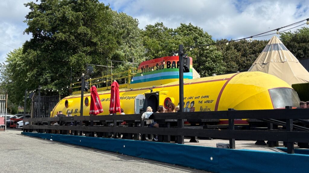 Front of the Yellow Submarine themed bar in the Baltic Triangle, Liverpool with people sitting outside.