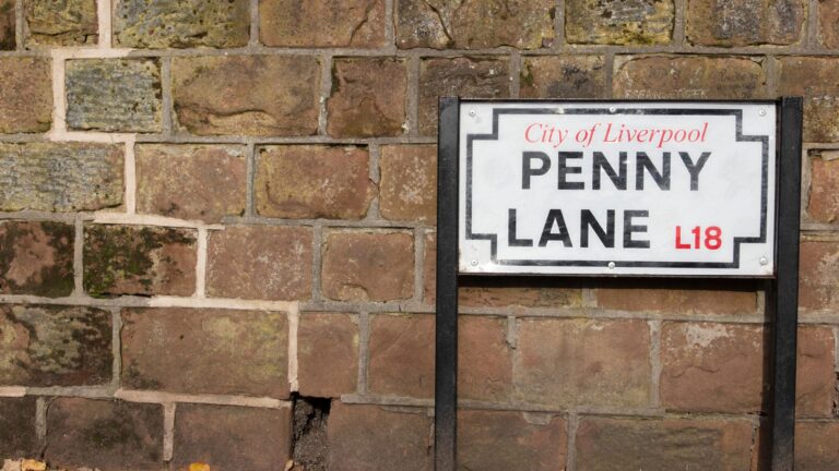 Street sign of Penny Lane Liverpool against a brick wall
