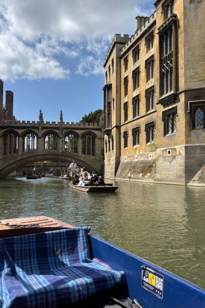 Punts on the River Cam with a stone bridge in the background in Cambridge, England, an easy day trip from London.