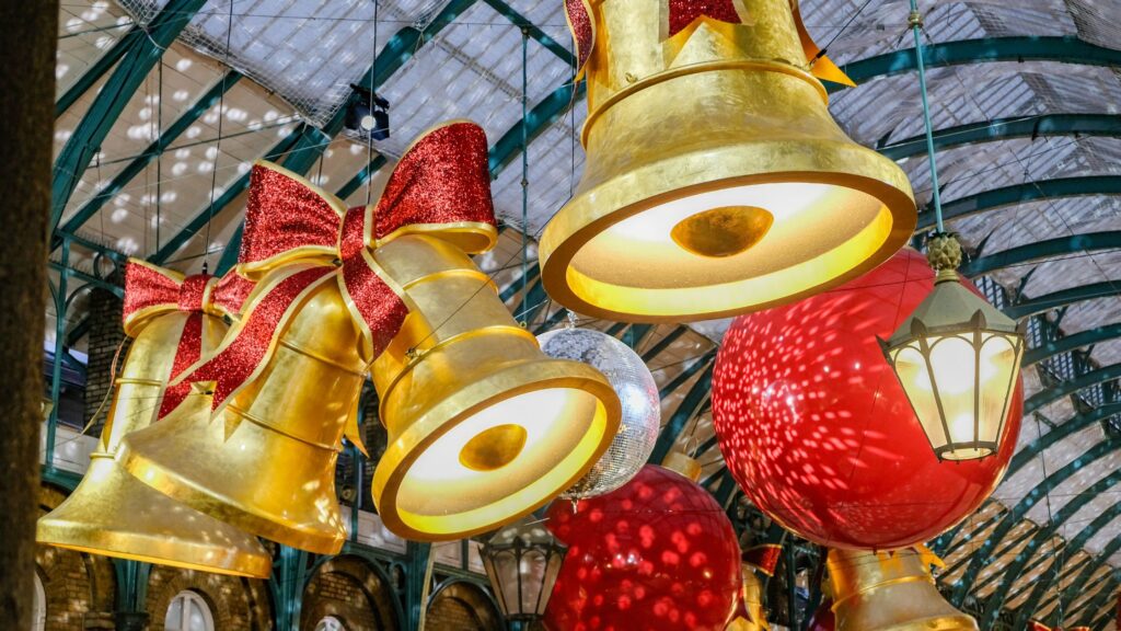 Gold Christmas bells hanging from Apple Market ceiling in Covent Garden showcasing London in winter.