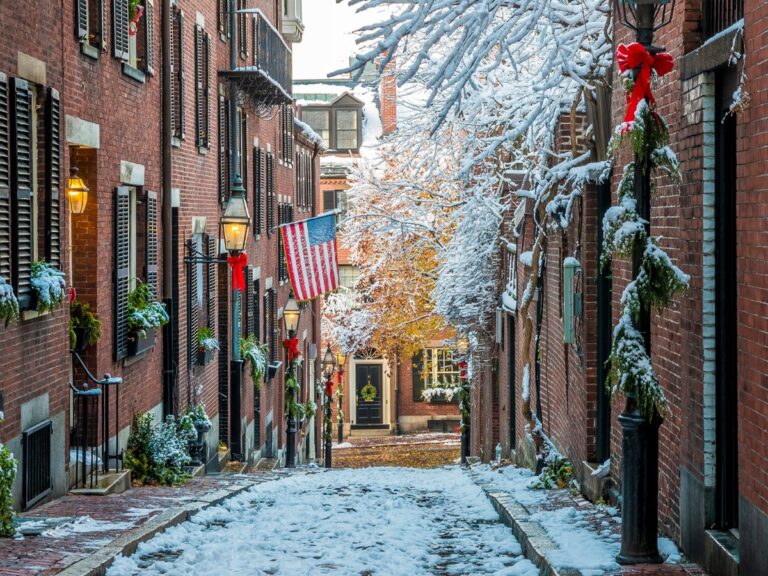 Beacon Hill’s Acorn Street in winter with snow and holiday decorations.