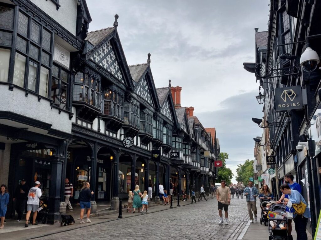 Streetscape of Northgate in Chester, England with unique "rows" on either side of central cobbled street featuring distinctive black and white timber architecture