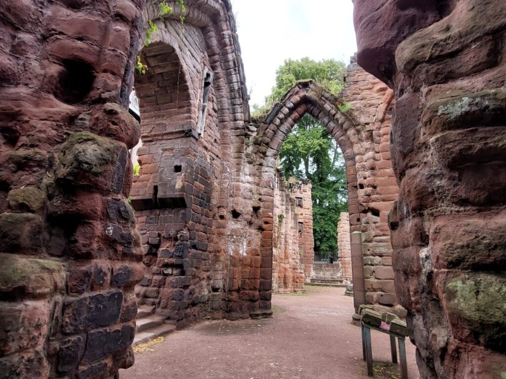 Ruins of St. John the Baptist Church in Chester with preserved Norman arch in local red sandstone.