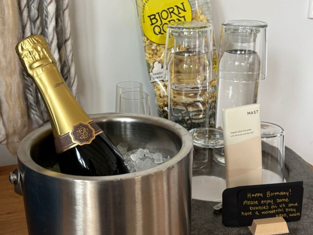 Bottle of champagne in ice bucket and happy birthday message.