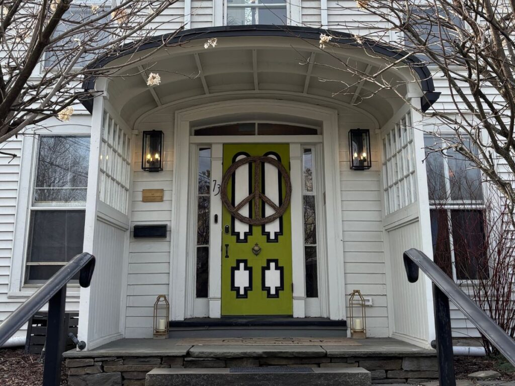 Green front door with hanging CND sign at the entrance to Twin Gables Guest House, Woodstock, NY