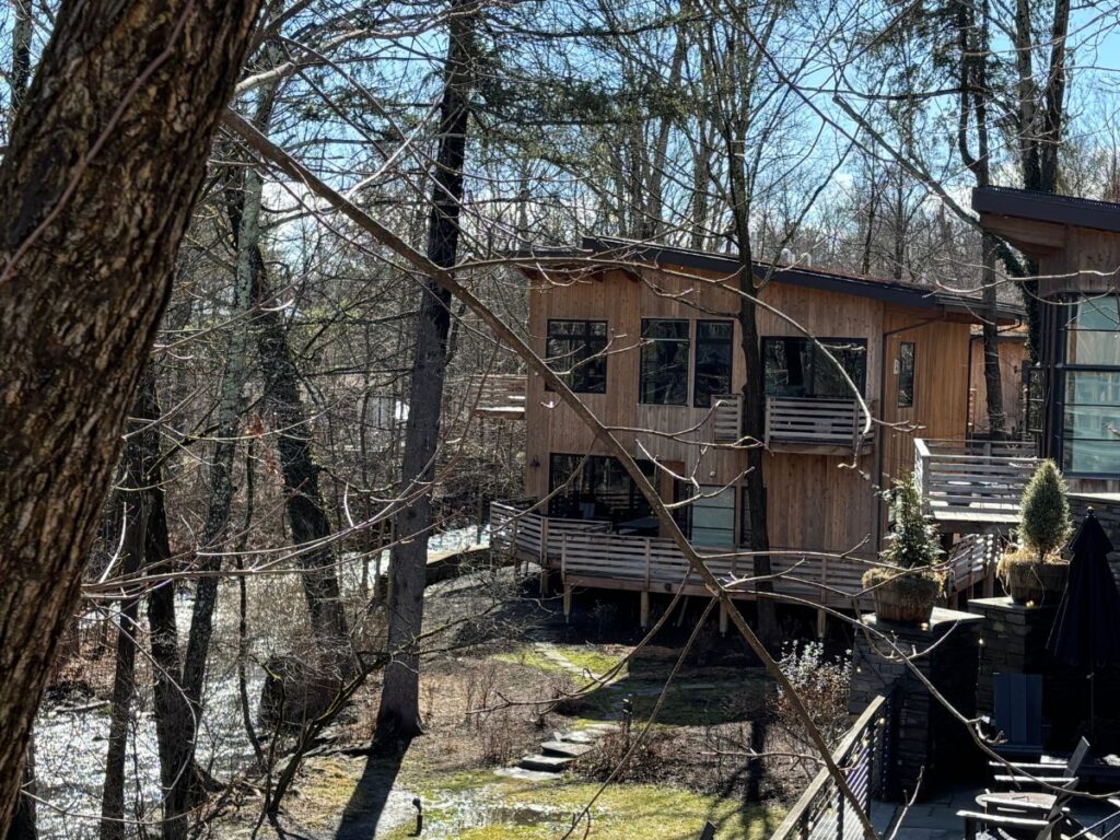 Wooden structure housing accommodation at the Woodstock Way Hotel in Woodstock, NY set in a wooded area in late winter.