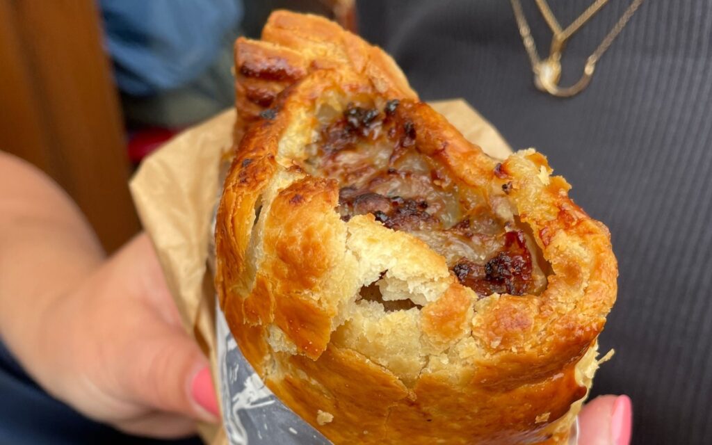 British sausage roll from The Ginger Pig at Borough Market London with flaky pastry crust and sausage filling.