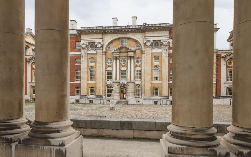 Exterior view of the Old Royal Naval College in Greenwich London as seen through two columns