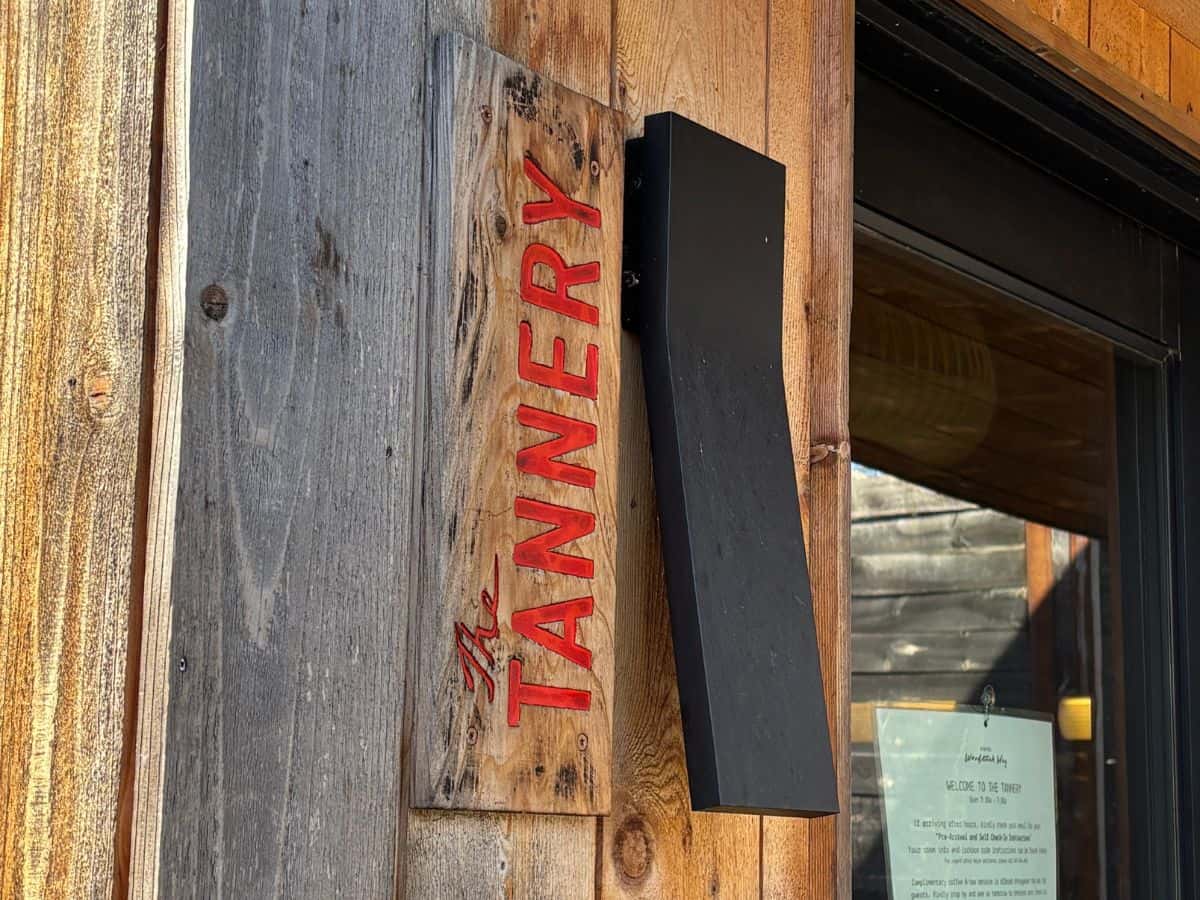Signage that reads The Tannery in wood outside timbered building with black modern light fixture at Woodstock Way Hotel.