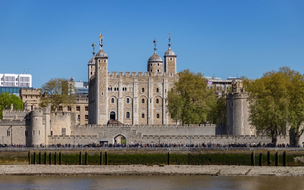 Tower of London as seen from the South Bank of the River Thames constructed of Portland Stone with castellations and four towers.