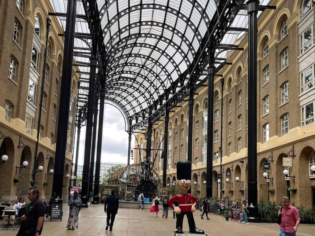 Distinctive glass roof of Hays Galleria on London's Southbank with steel beams and pillars connecting former industrial warehouses turned shopping district.