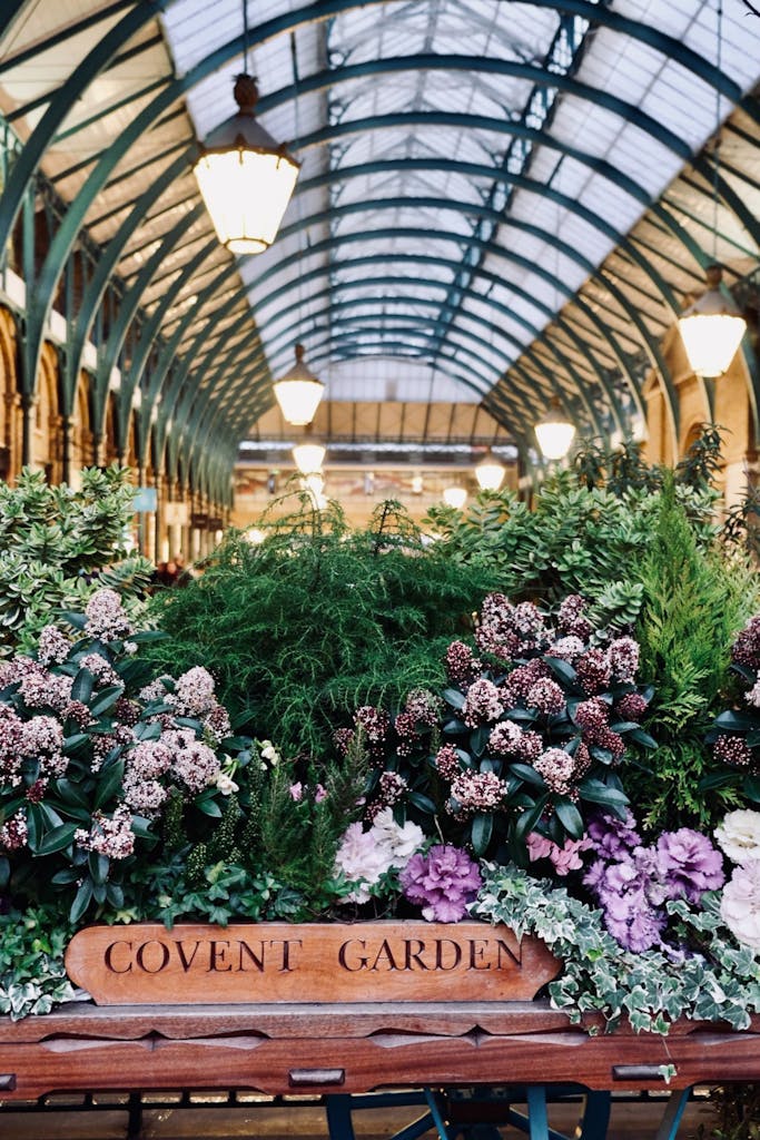 Vibrant floral arrangement at Covent Garden, showcasing lush greenery indoors under iconic arches in London.