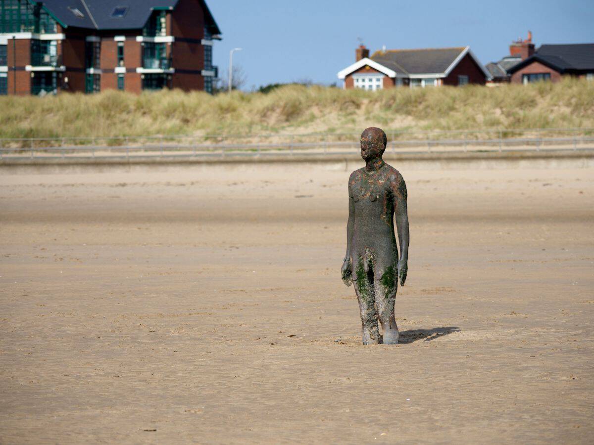 One of the bronze statues at Crosby beach, Merseyside looking back towards to the beach.