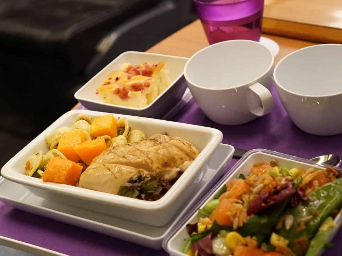 Close up of an example of airline food served in flight in individual compartments on a white tray