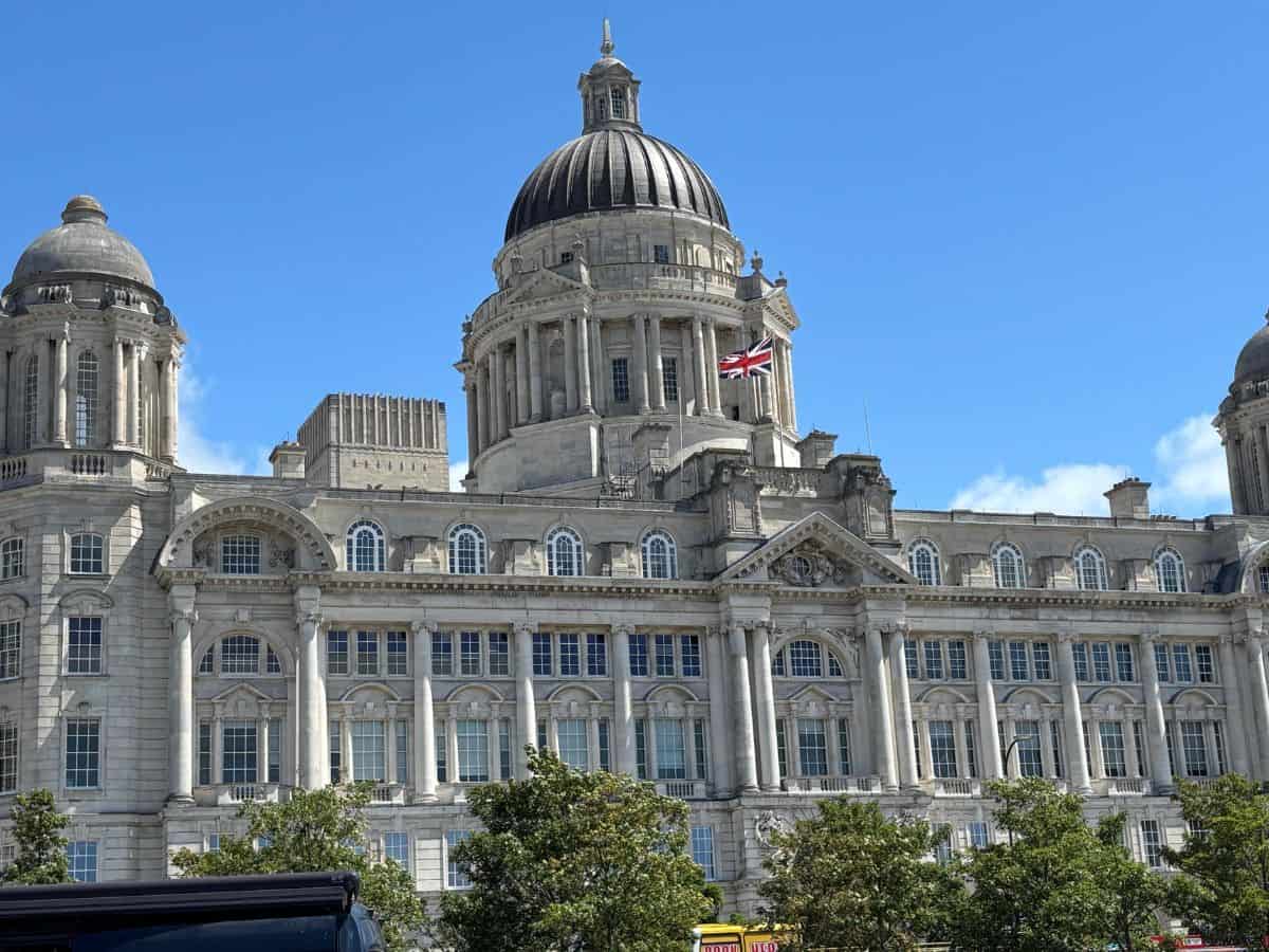 Port of Liverpool building on Liverpool's waterfront in white stone and decorative center dome against blue sky.