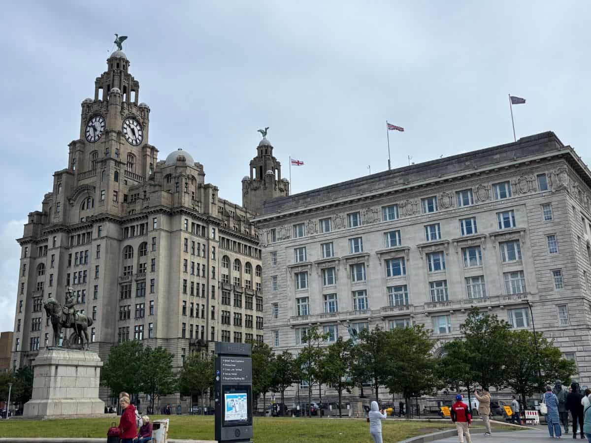 Royal Liver Building and Cunard Building at Liverpool's waterfront with Edvard VII statue in foreground as seen on a cloudy day.