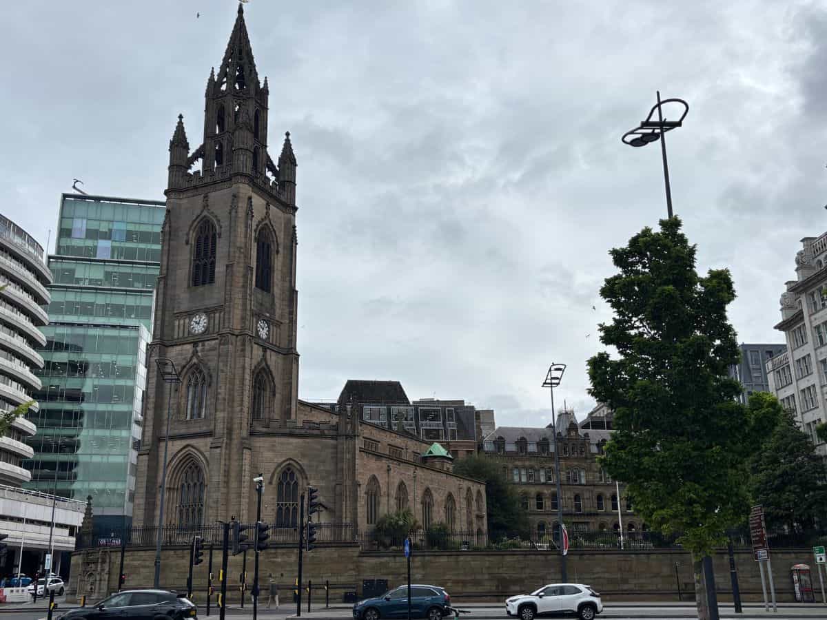 Here's the alt text:
Our Lady and St Nicholas Sailors Church Liverpool clock tower viewed from Pier Head on cloudy day